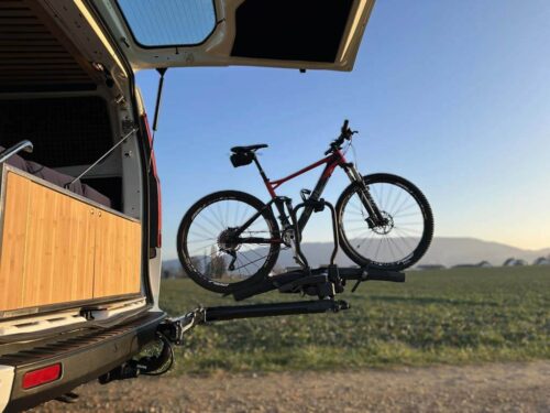 Bras pivotant pour porte-vélos sur boule d’attelage SpaceMaker Bras pivotant SpaceMaker avec un vélo chargé et hayon du van ouvert