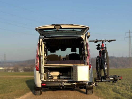 Bras pivotant pour porte-vélos sur boule d’attelage SpaceMaker Bras pivotant SpaceMaker avec un vélo chargé et hayon du van ouvert