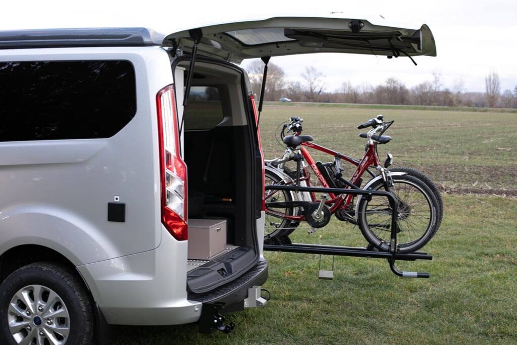 Swinging bike rack to fully open the tailgate